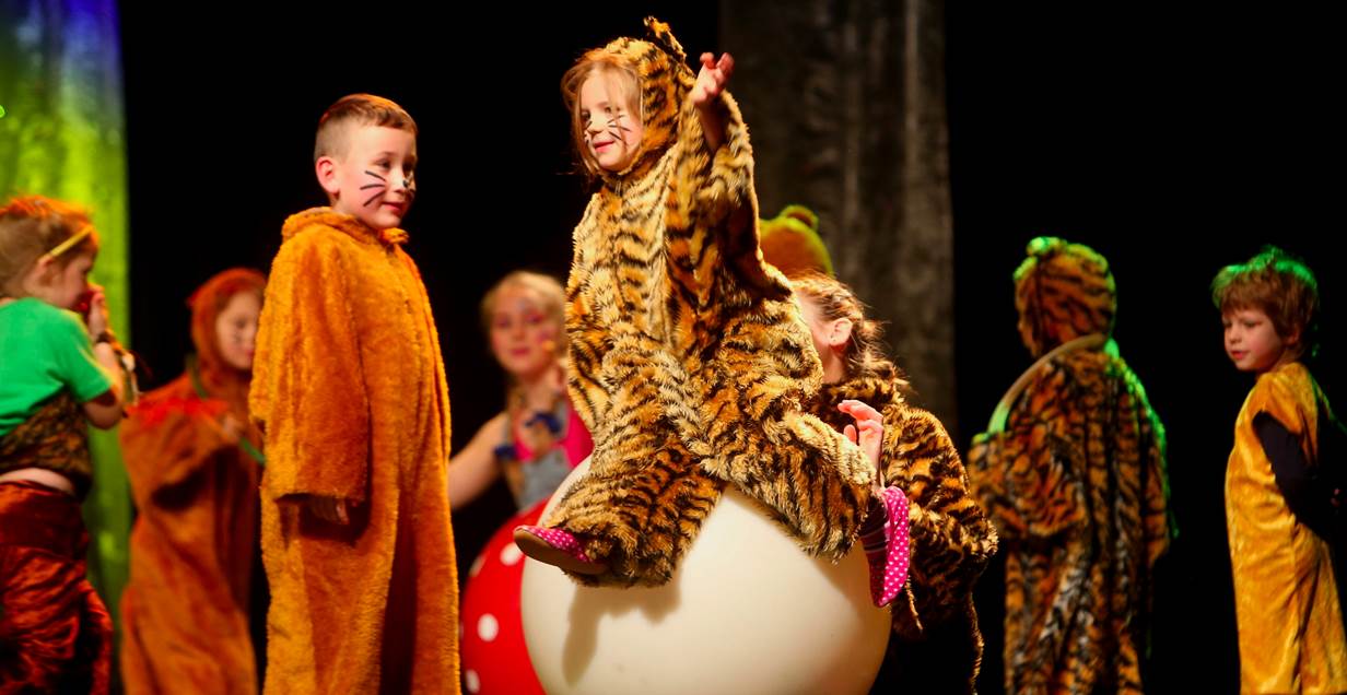 Als Löwen und Tiger verkleidete Kinder auf einer Bühne; Quelle: Christian Kosak