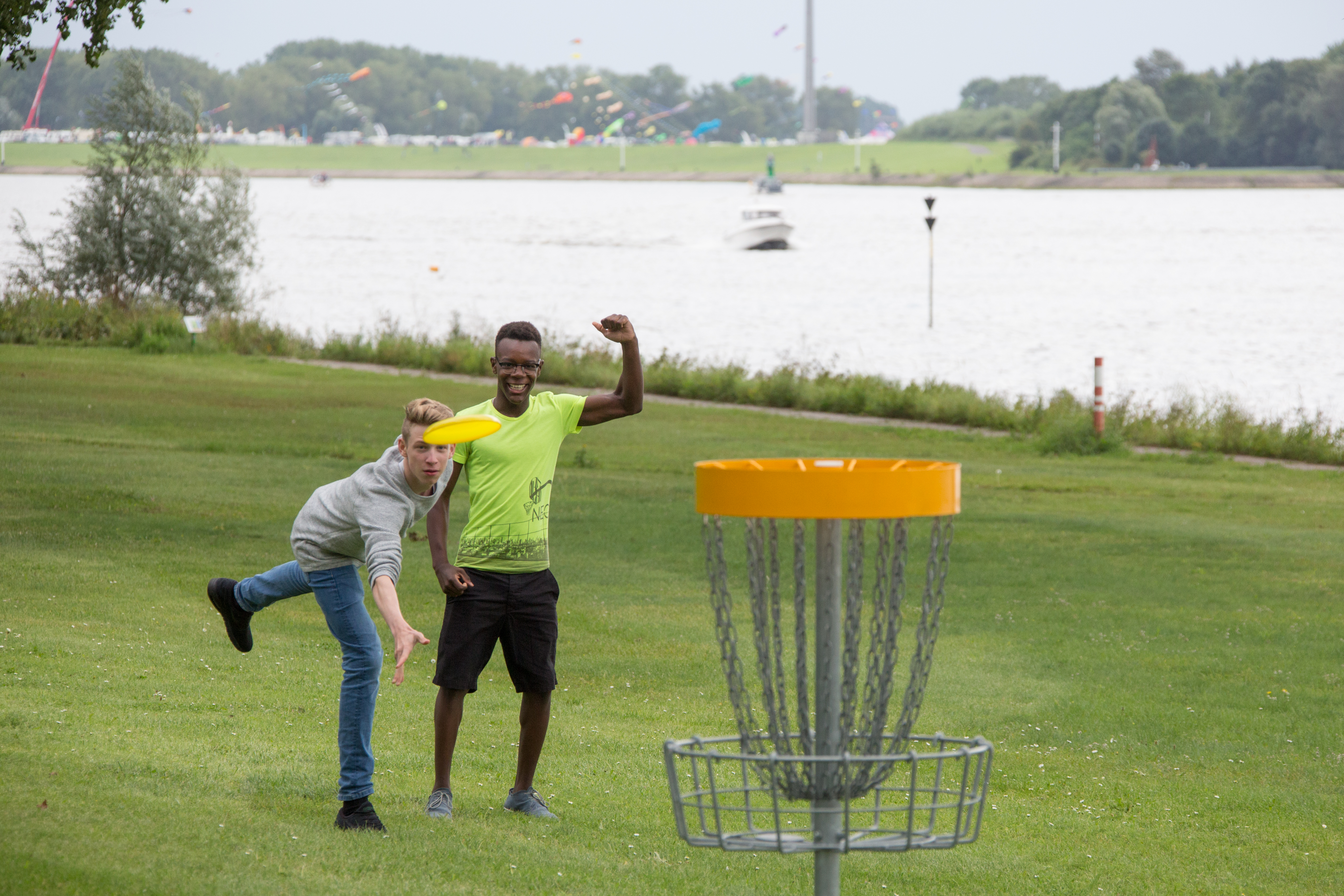 Zwei Jugendliche spielen am Deich Frisbee