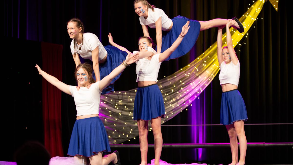 5 Akrobatinnen führen einen Trick auf der Bühne auf