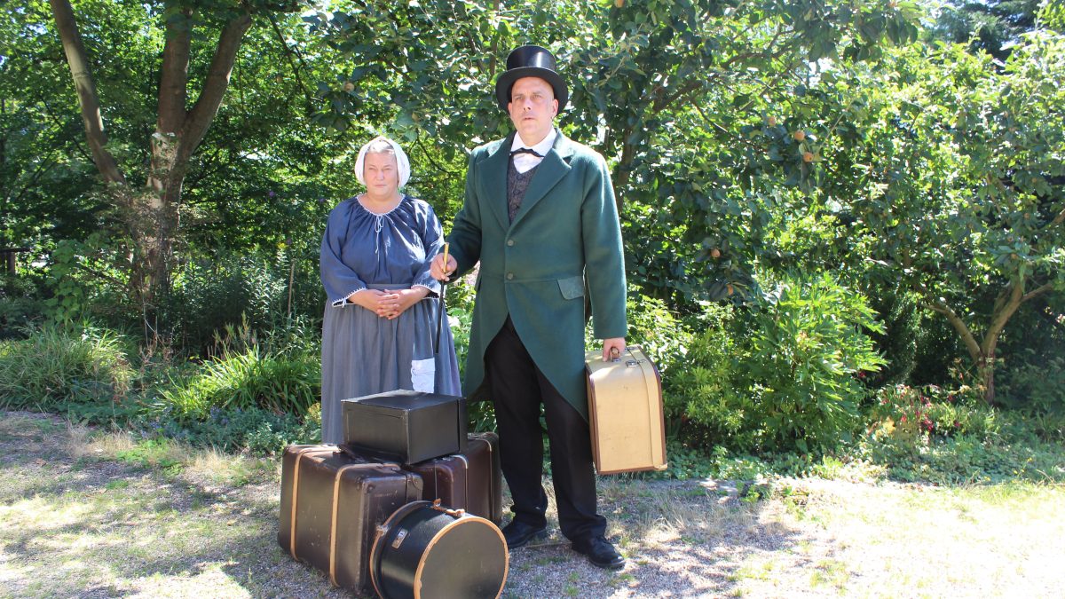 Eine Frau und ein Mann stehen in Kleidung aus dem 19. Jahrhunderft draußen