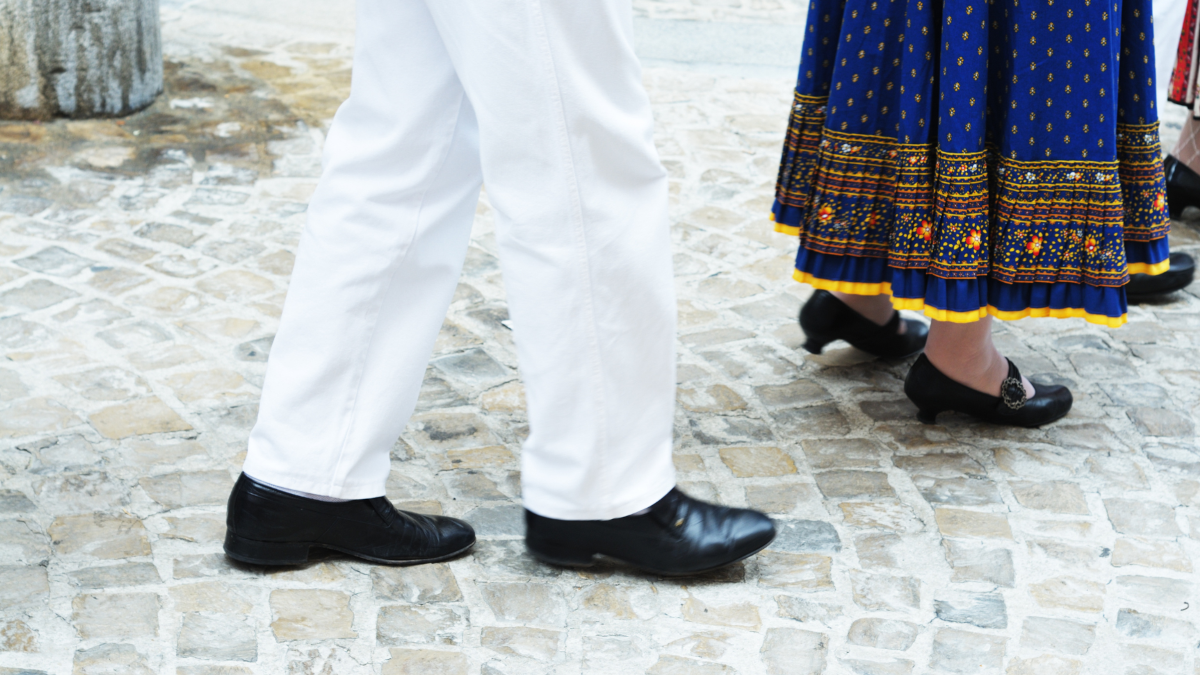 Zwei Paar Beine in schicken Schuhen sind erkennbar, während sie tanzen.