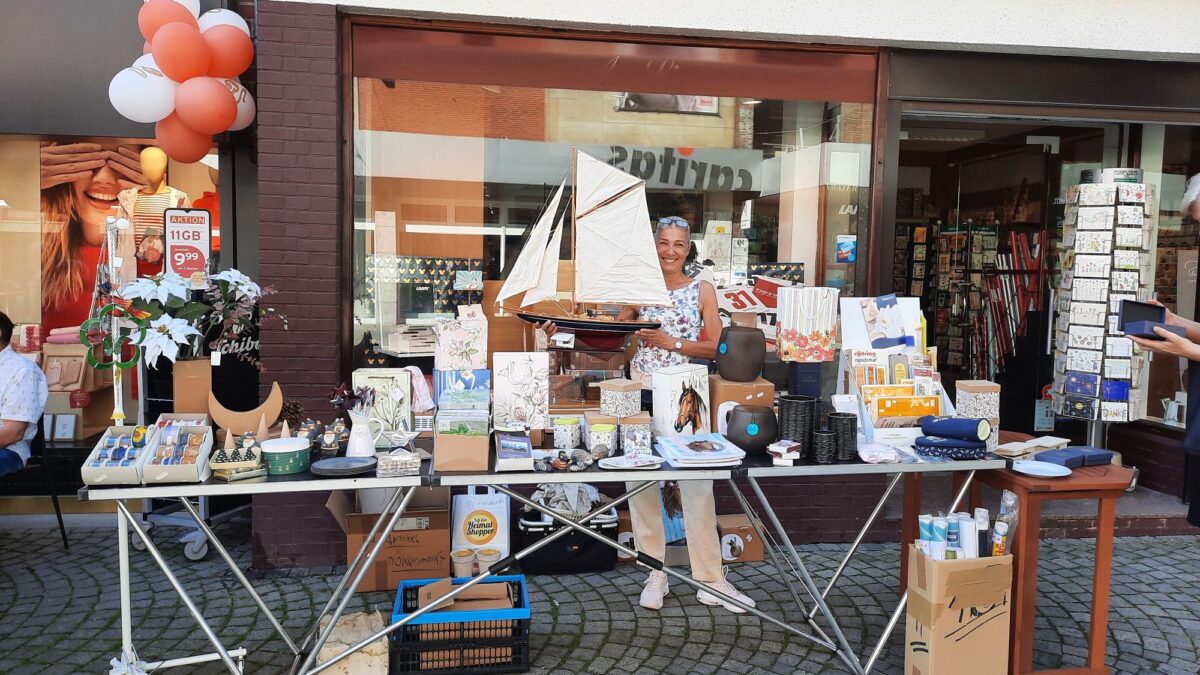 Eine Frau steht an einem Flohmarkt Stand